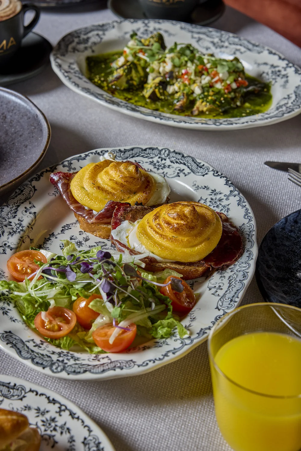Huevos benedictinos, ensalada y zumo en el brunch de Leña Madrid